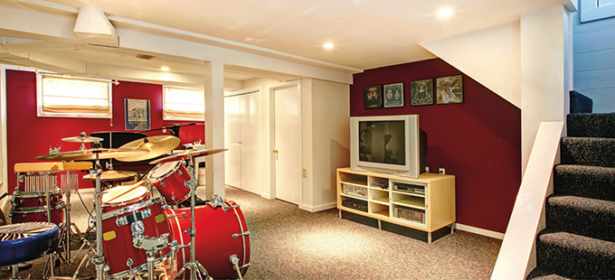 Ein Wohnzimmer mit einem Schlagzeug und roten Wänden (gesunde Raumluft im Keller).