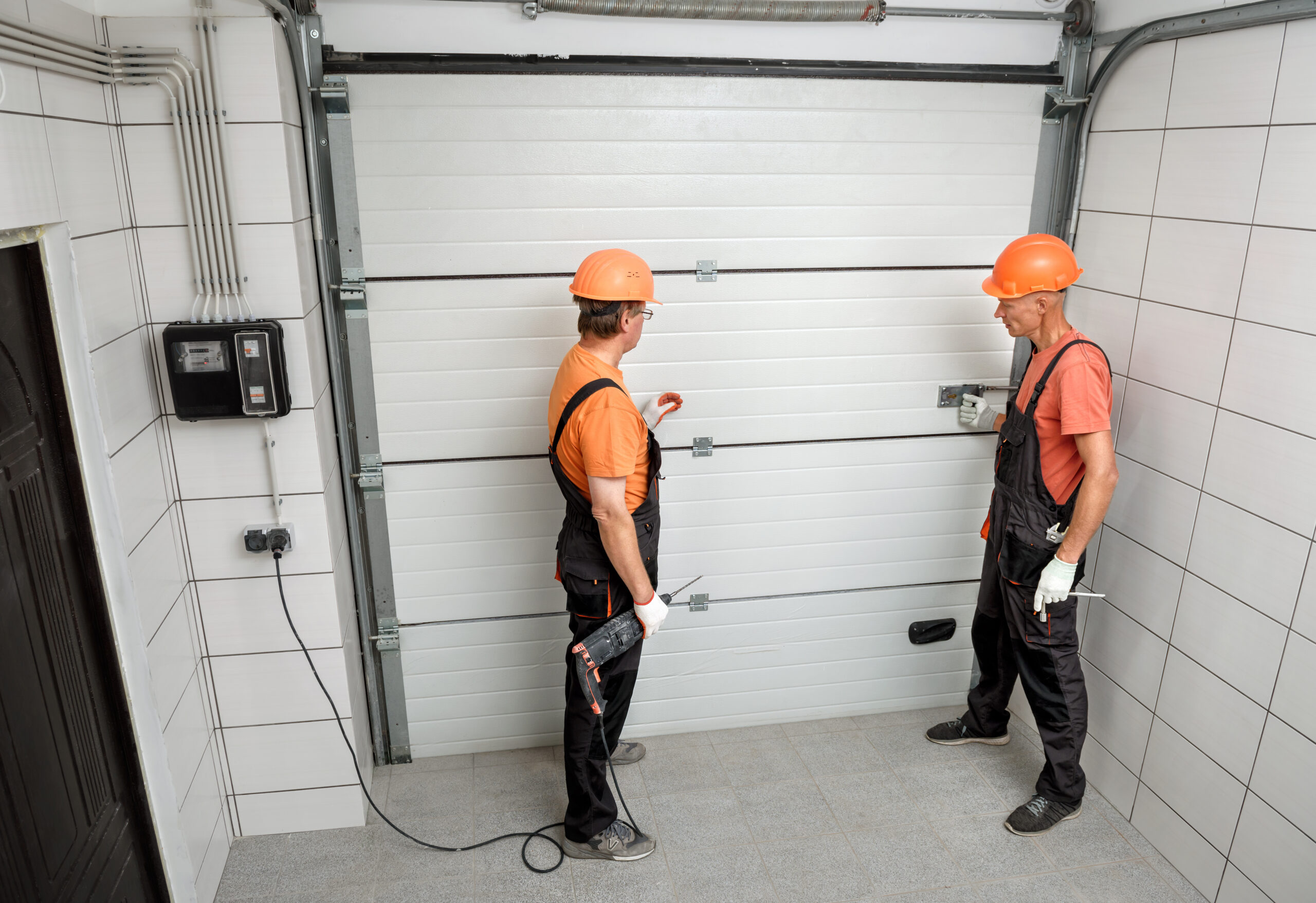 Zwei Arbeiter installieren ein Garagentor