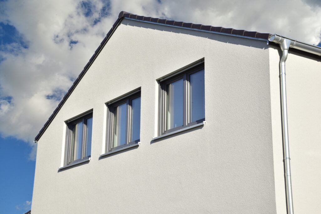 Hausfassade mit zwei Fenstern.