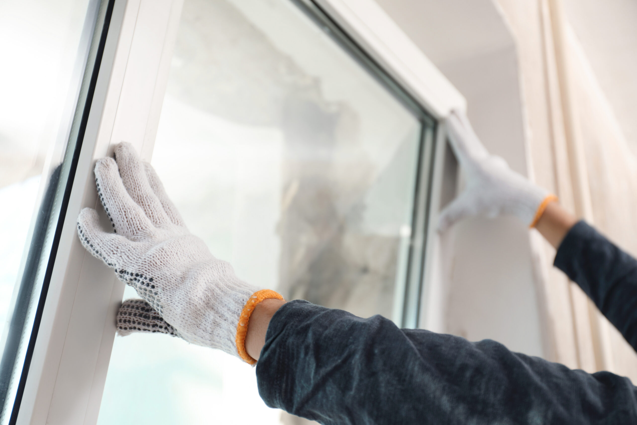 Energieeffiziente Modernisierung: Eine Person fügt ein Fenster in einer Einrichtung ein.